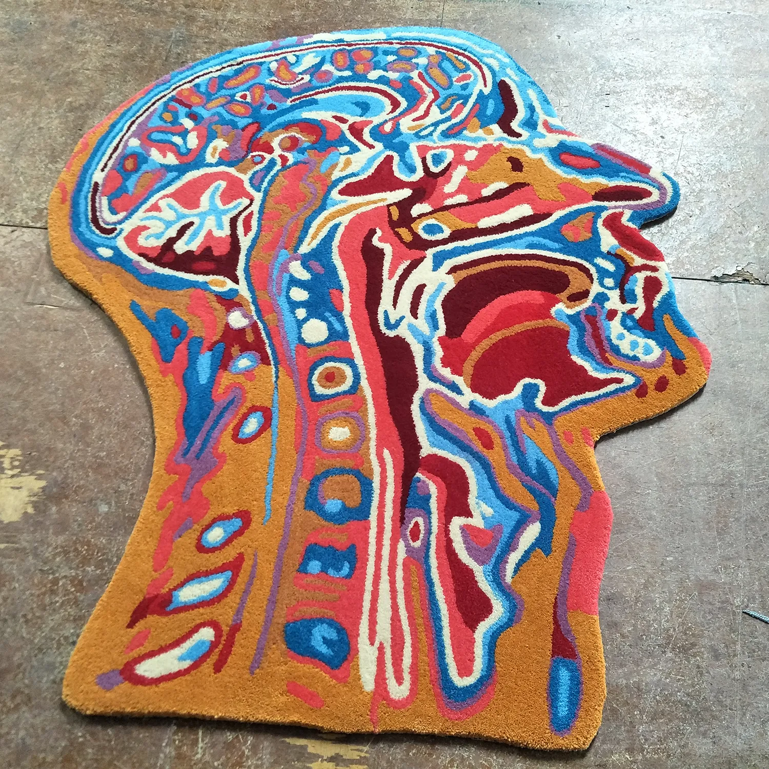 A modern custom tufted area rug with cool abstract art design in a living room.